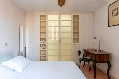 a bedroom with a bed and a desk next to a table at Manara 29 - FromHometoRome in Rome