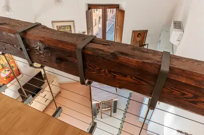 a large wooden beam on display in a room at Manara 29 - FromHometoRome in Rome