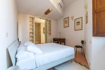 a bedroom with a white bed and a desk at Manara 29 - FromHometoRome in Rome