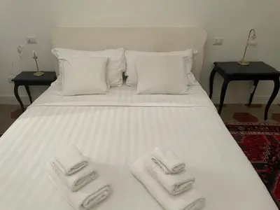 a large white bed with two towels on it at Apartment Luxury Navona in Rome