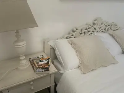a bed with a lamp and a book on a side table at Apartment Luxury Navona in Rome