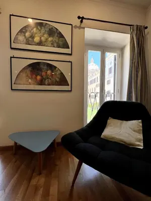 a living room with a couch and a painting on the wall at Campo dei fiori - cozy and central apt in Rome