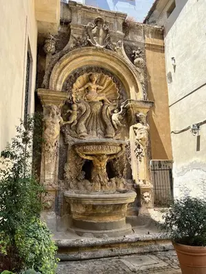 a stone fountain on the side of a building at Campo dei fiori - cozy and central apt in Rome
