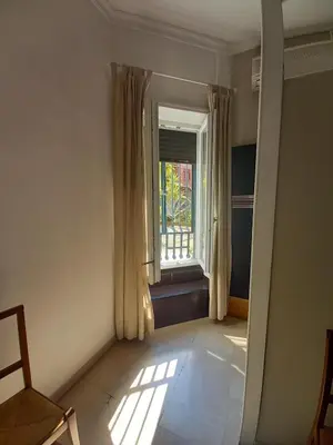 an empty room with a window and a chair at Caffarella Apartment in Rome