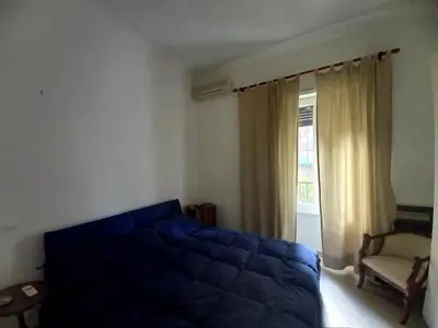 a bedroom with a blue bed and a window at Caffarella Apartment in Rome