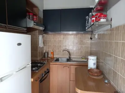 a small kitchen with wooden cabinets and a sink at Caffarella Apartment in Rome