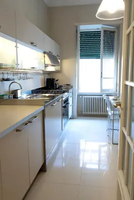 a large kitchen with white cabinets and a sink at Moon Cove, Villa Borghese Prestige Hideaway Rome in Rome