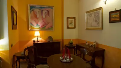 a dining room with tables and chairs and a painting of toes at Hotel Benedetto in Rome