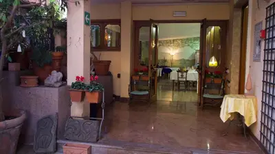 an entrance to a restaurant with a table and chairs at Hotel Benedetto in Rome