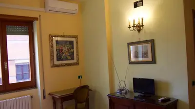 a room with a desk with a computer and a window at Hotel Benedetto in Rome