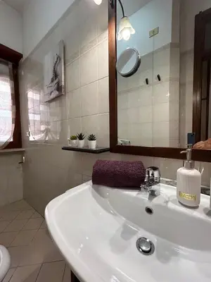 a white bathroom with a sink and a mirror at La Camilla in Rome