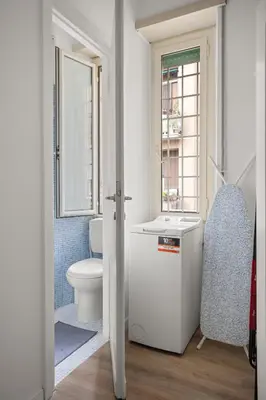 a white bathroom with a toilet and a window at Maison G - new design apartment with balcony in Rome