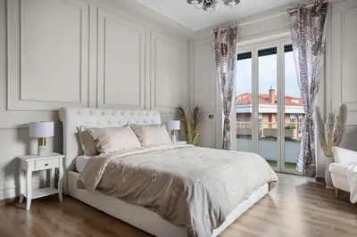 a white bedroom with a bed and a window at Maison G - new design apartment with balcony in Rome