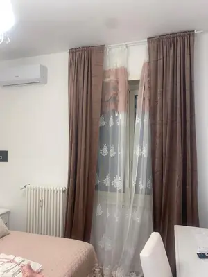 a bedroom with a bed and a window with curtains at Colosseo luxury home in Rome