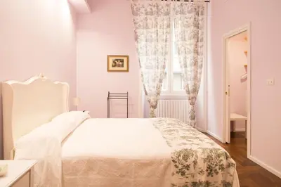 a white bedroom with a bed and a window at Arcudi Romance Home in Rome