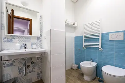 a bathroom with a toilet and a sink and a mirror at Arcudi Romance Home in Rome