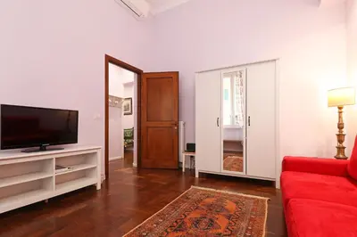 a living room with a red couch and a television at Arcudi Romance Home in Rome