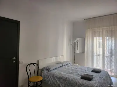 a bedroom with a bed and a chair and a window at P7 Casa Roma in Rome