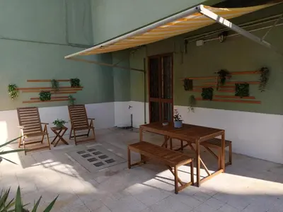 a patio with chairs and a table and awning at CASA NONNO - Casa Vacanze in Rome