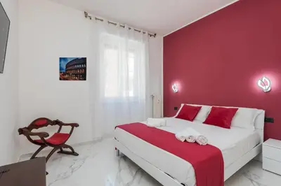 a red and white bedroom with a bed and a chair at Casa di Gina in Rome