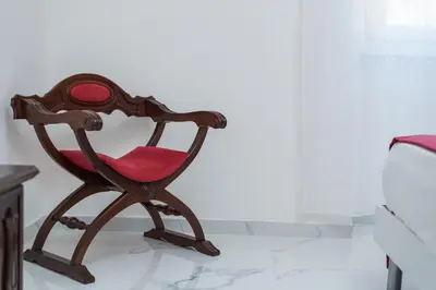 a wooden chair with a red seat in a room at Casa di Gina in Rome