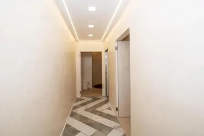 a hallway with white walls and a checkered floor at Enjoy Colosseum Apartment in Rome
