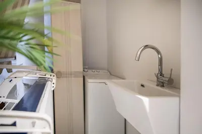 a bathroom with a sink and a washing machine at Enjoy Colosseum Apartment in Rome