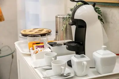 a coffee maker sitting on a kitchen counter with cups at Enjoy Colosseum Apartment in Rome
