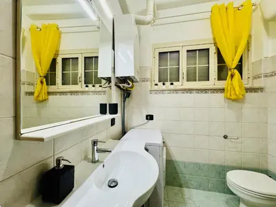 a white bathroom with a sink and a toilet at Via Arese Apartment in Rome