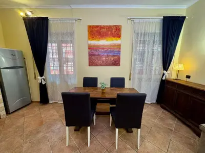 a dining room with a wooden table and chairs at Via Arese Apartment in Rome