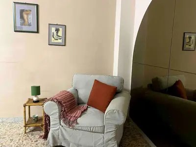 a white chair with a red pillow in a room at Home Luxury Emy in Rome