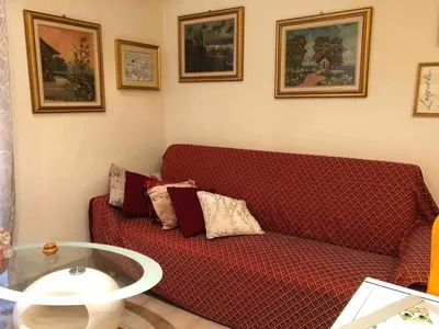 a living room with a red couch and a glass table at Appartamento a due passi dalla Storia e dalla Movida Romana in Rome