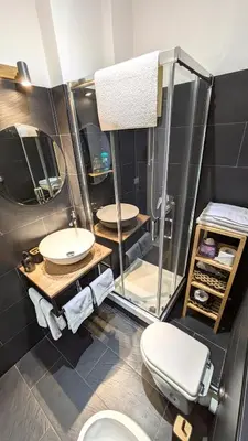 a bathroom with two sinks and a toilet and a mirror at Giuliana32 in Rome