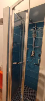 a shower in a bathroom with a blue wall at Gelsomino a San Pietro in Rome