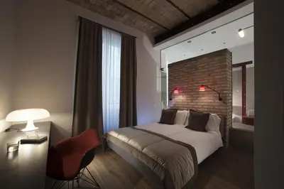 a bedroom with a bed and a brick wall at Atypical Rooms in Rome