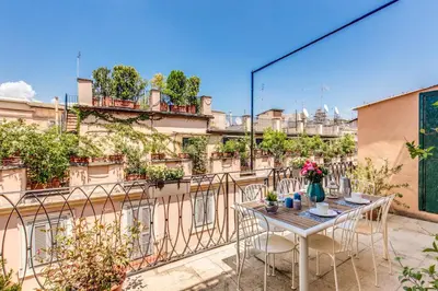 a patio with a table and chairs on a balcony at AwesHomeItaly - Spagna Glamour Life Penthouse in Rome