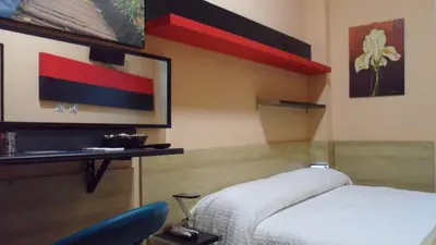 a room with a bed and a chair and paintings at Gina B&B in Rome