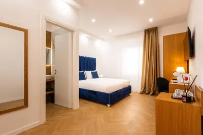 a bedroom with a white bed and a television on the wall at Affresco LR Collection in Rome