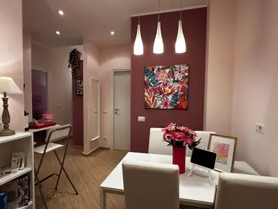 a living room with a white table and a painting at Ostiense - San Paolo Garbatella - Università Roma 3 in Rome