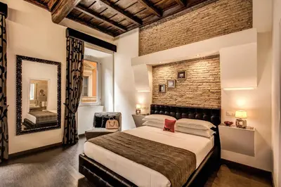 a bedroom with a large bed and a brick wall at Piazza di Spagna Comfort Rooms in Rome