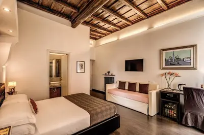 a bedroom with a bed and a couch and a television at Piazza di Spagna Comfort Rooms in Rome