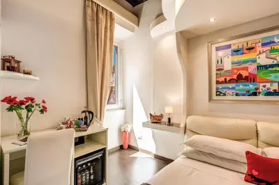a living room with a couch and a painting on the wall at Piazza di Spagna Comfort Rooms in Rome