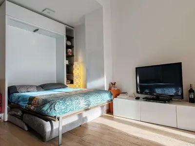 a bedroom with a bed and a flat screen tv at Ancient Rome Studio in Rome