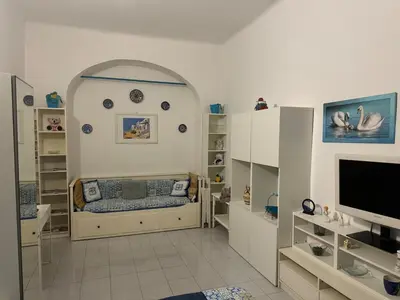 a room with a bed and a tv and shelves at SweetHome Lisa in Rome