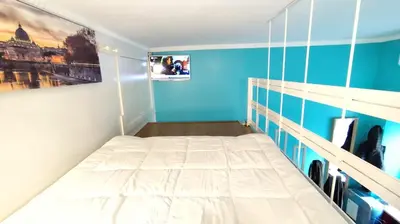 a bedroom with a white bed and a blue wall at Appartamento esclusivo Casalino Vatican Suite in Rome