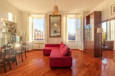a living room with a red couch and a table at Esquilino Lightsome Apartment in Rome