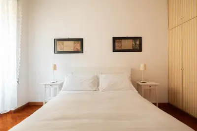 a bedroom with a large white bed with two tables at Esquilino Lightsome Apartment in Rome