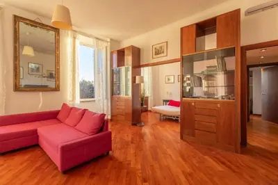 a living room with a red couch and wooden floors at Esquilino Lightsome Apartment in Rome
