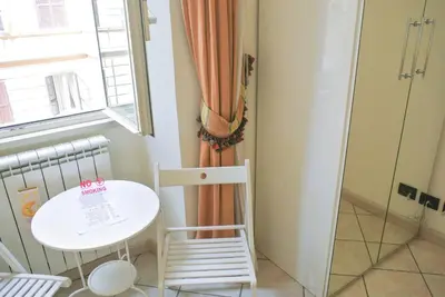 a small white table and chair in a room with a window at LarissaRooms in Rome