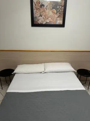 a bed in a room with a painting on the wall at LarissaRooms in Rome
